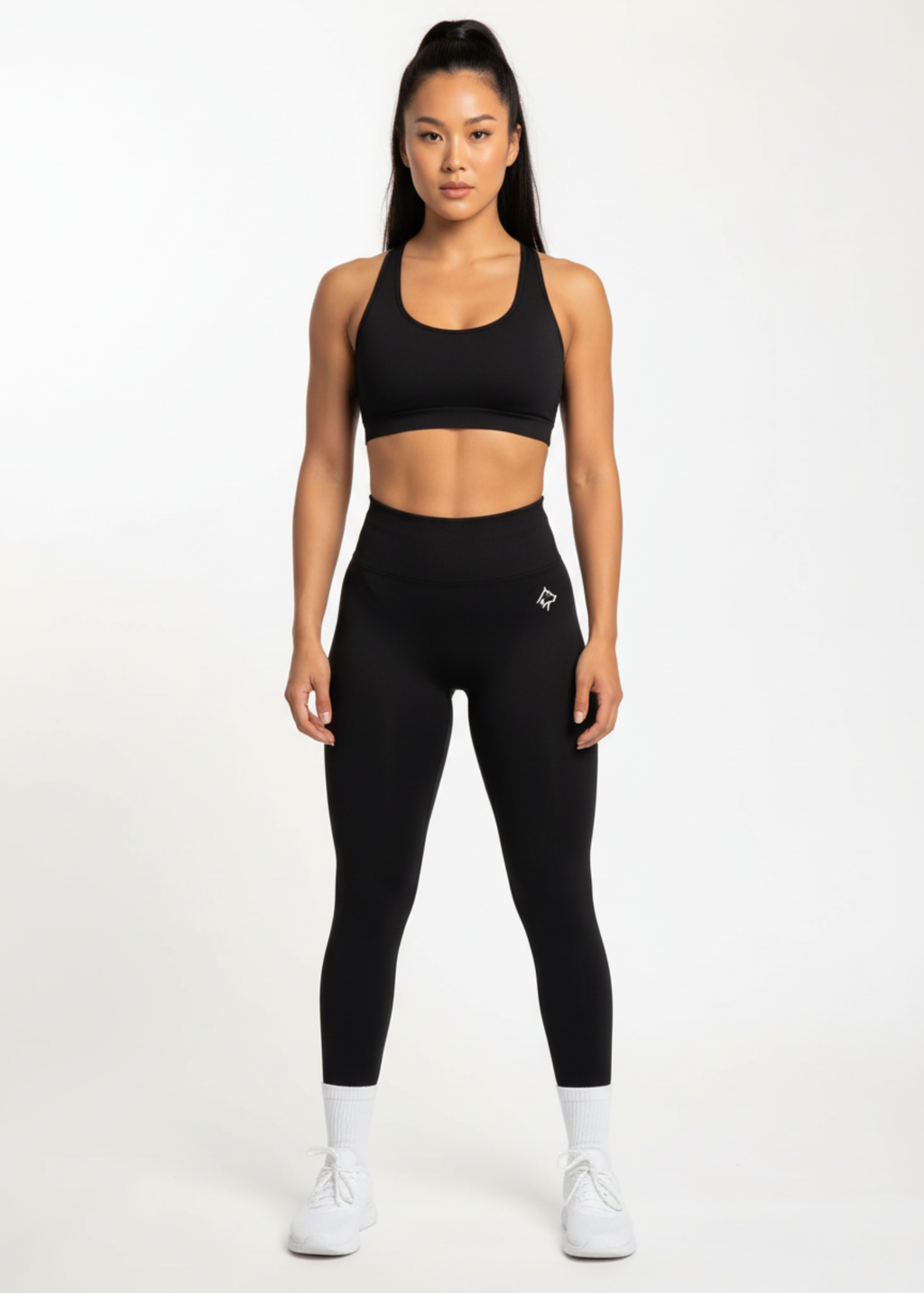 Woman in black high-waisted leggings and sports bra, fitness activewear for training and gym workouts