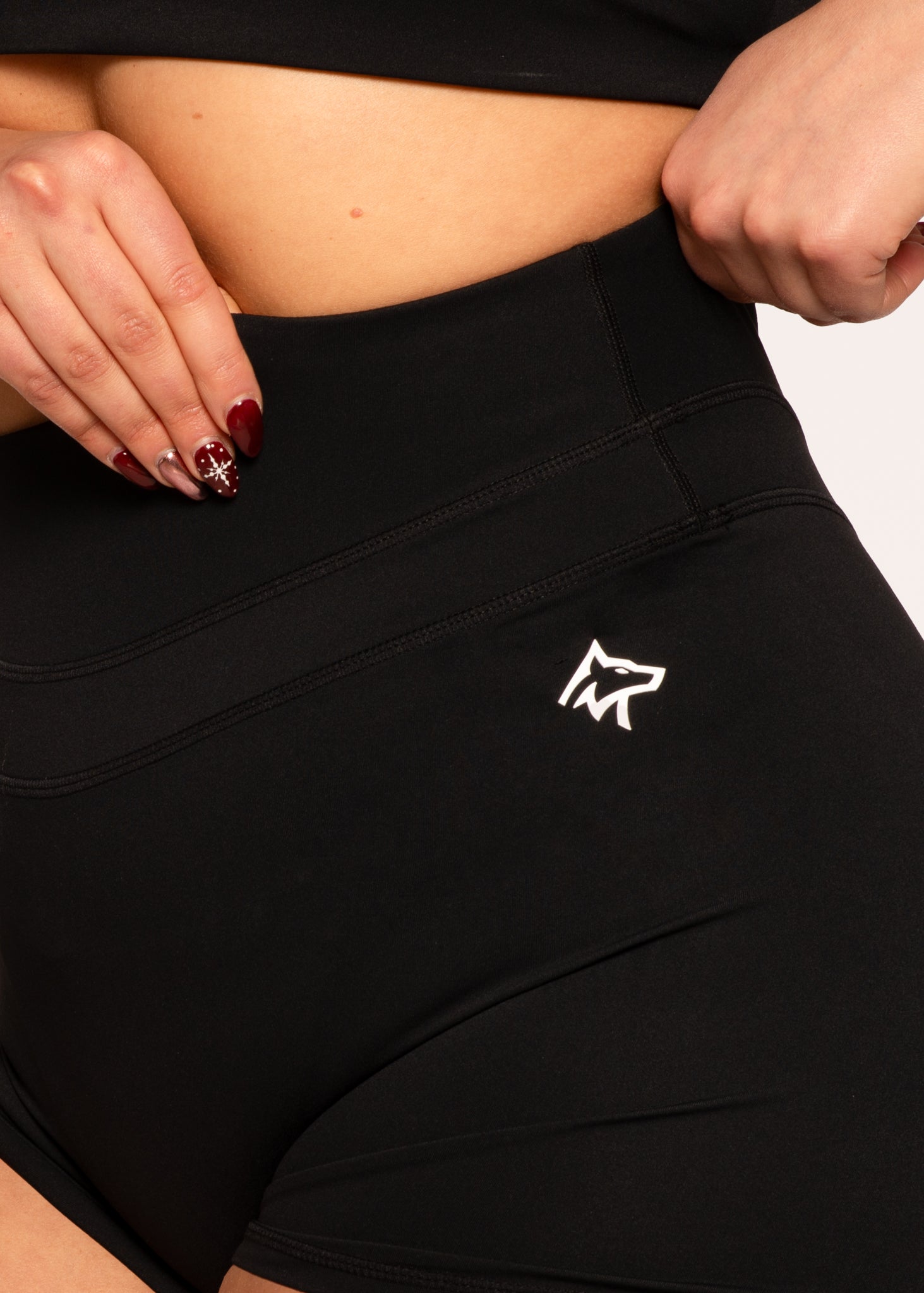 Black high-waisted gym shorts with white wolf logo, designed for comfort and performance during workouts.