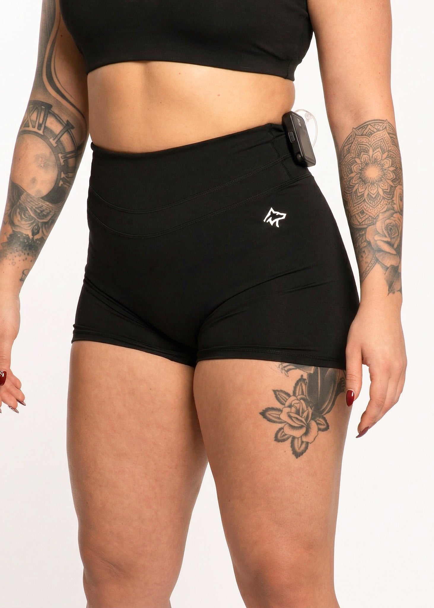 Black high-waisted gym shorts with side pocket, worn with crop top, ideal for training and fitness activities