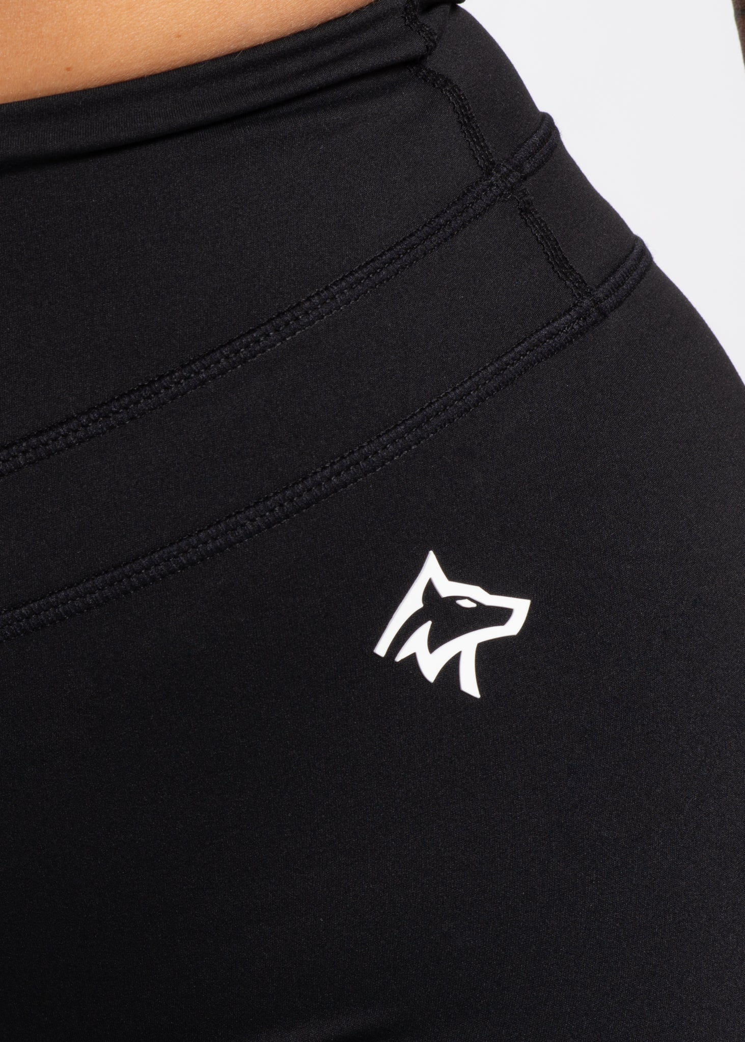 Black high-waisted gym leggings with white wolf logo, designed for comfort and performance during workouts.