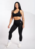 Woman in black high-waisted leggings and sports bra, fitness activewear for training and lifestyle