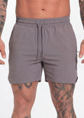 Grey drawstring gym shorts with side logo, worn by tattooed man for workout or casual wear