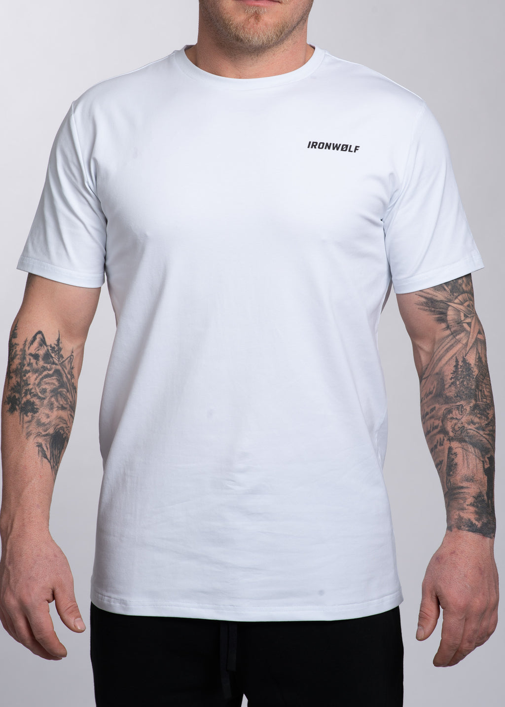 White IRONWØLF gym t-shirt with chest logo, worn by tattooed man for workout or casual wear