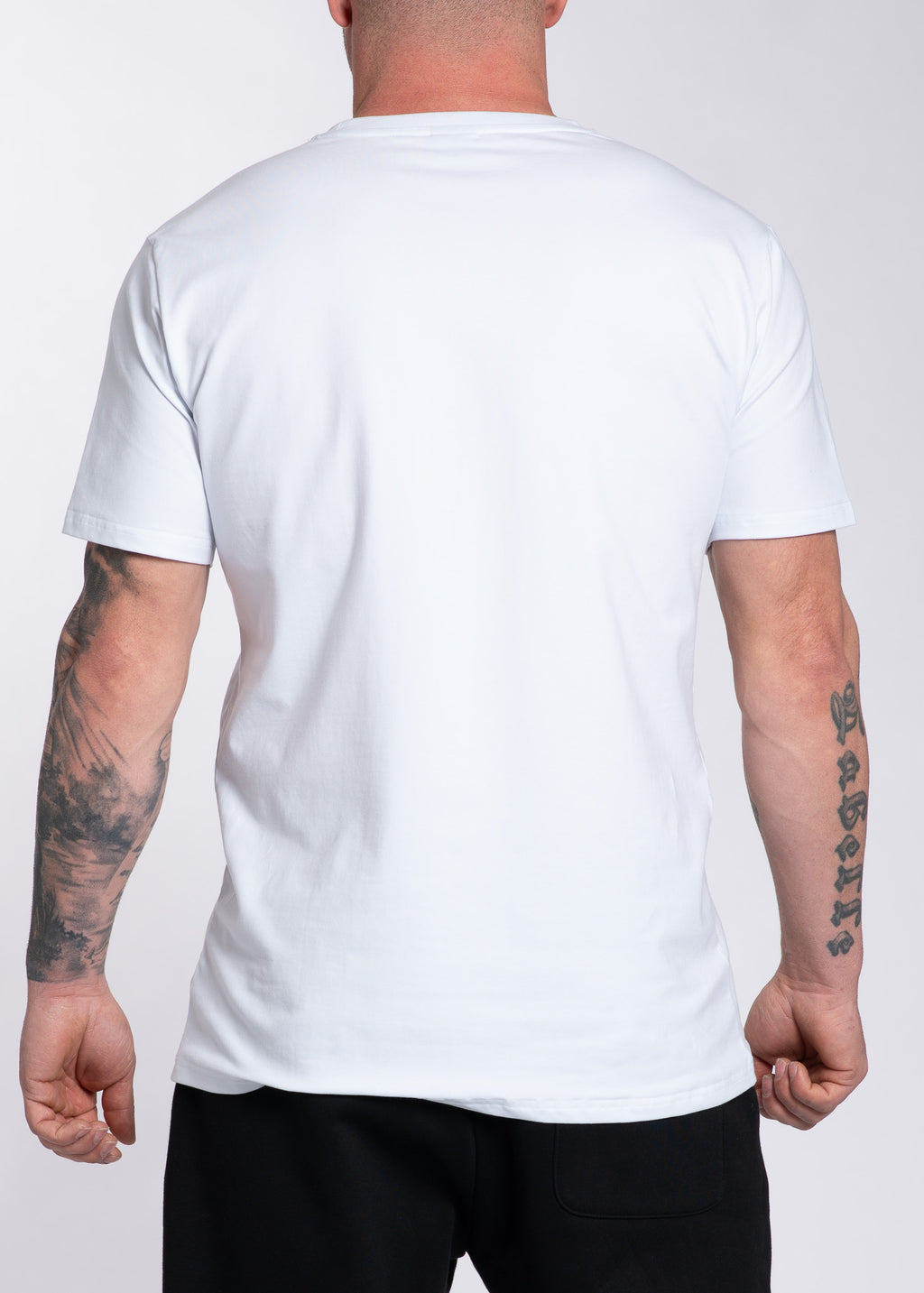 Man wearing white gym t-shirt with tattooed arms, back view, fitness apparel for training and lifestyle