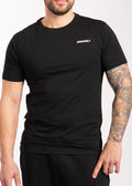 Man wearing black IRONWØLF gym t-shirt with white logo, showcasing athletic fit and tattooed arm
