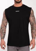 Man wearing black IRONWØLF sleeveless gym shirt with chest logo, showcasing tattooed arms and athletic fit.