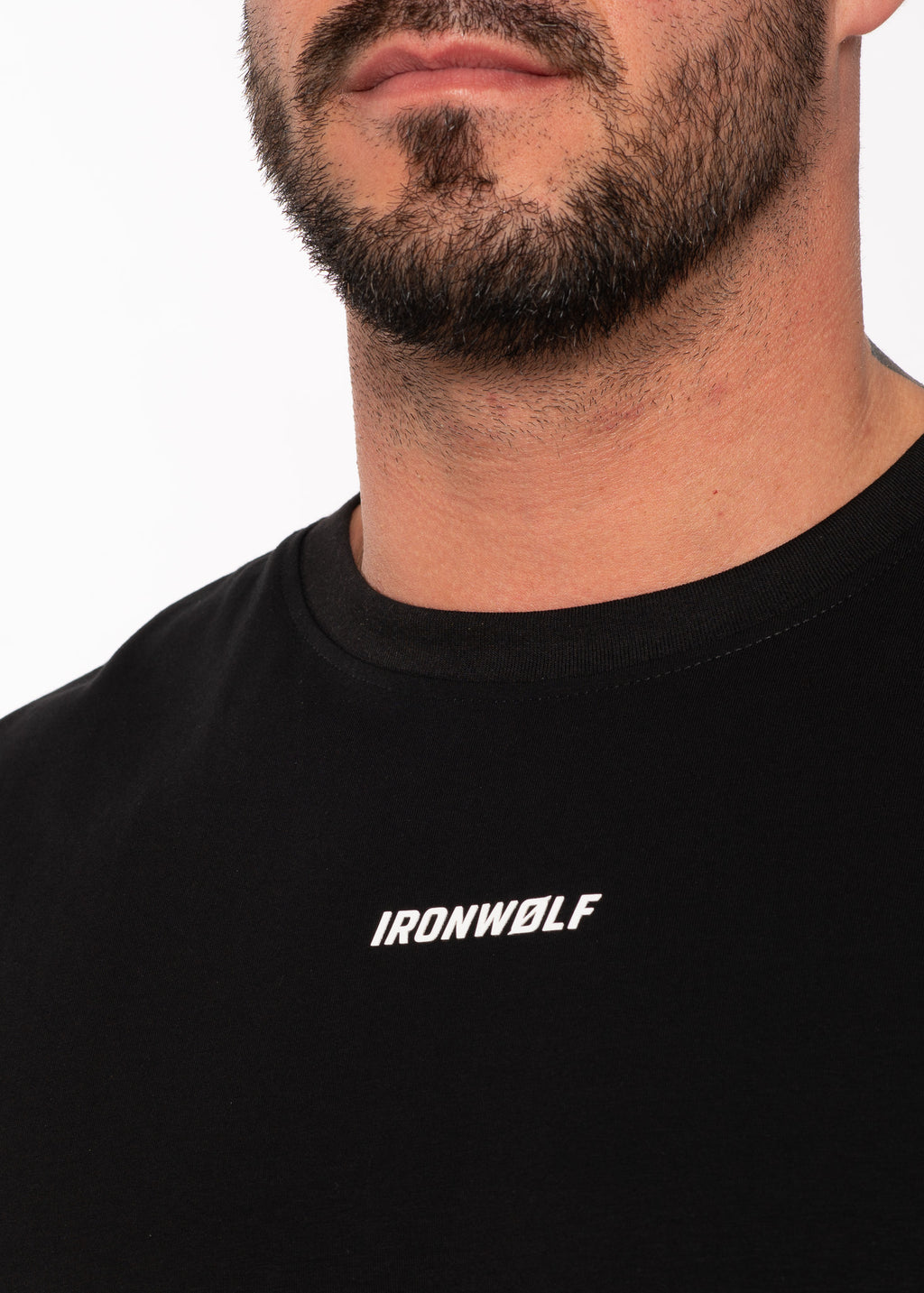 Man wearing black IRONWØLF gym tee with white logo, showcasing athletic activewear for training and lifestyle.
