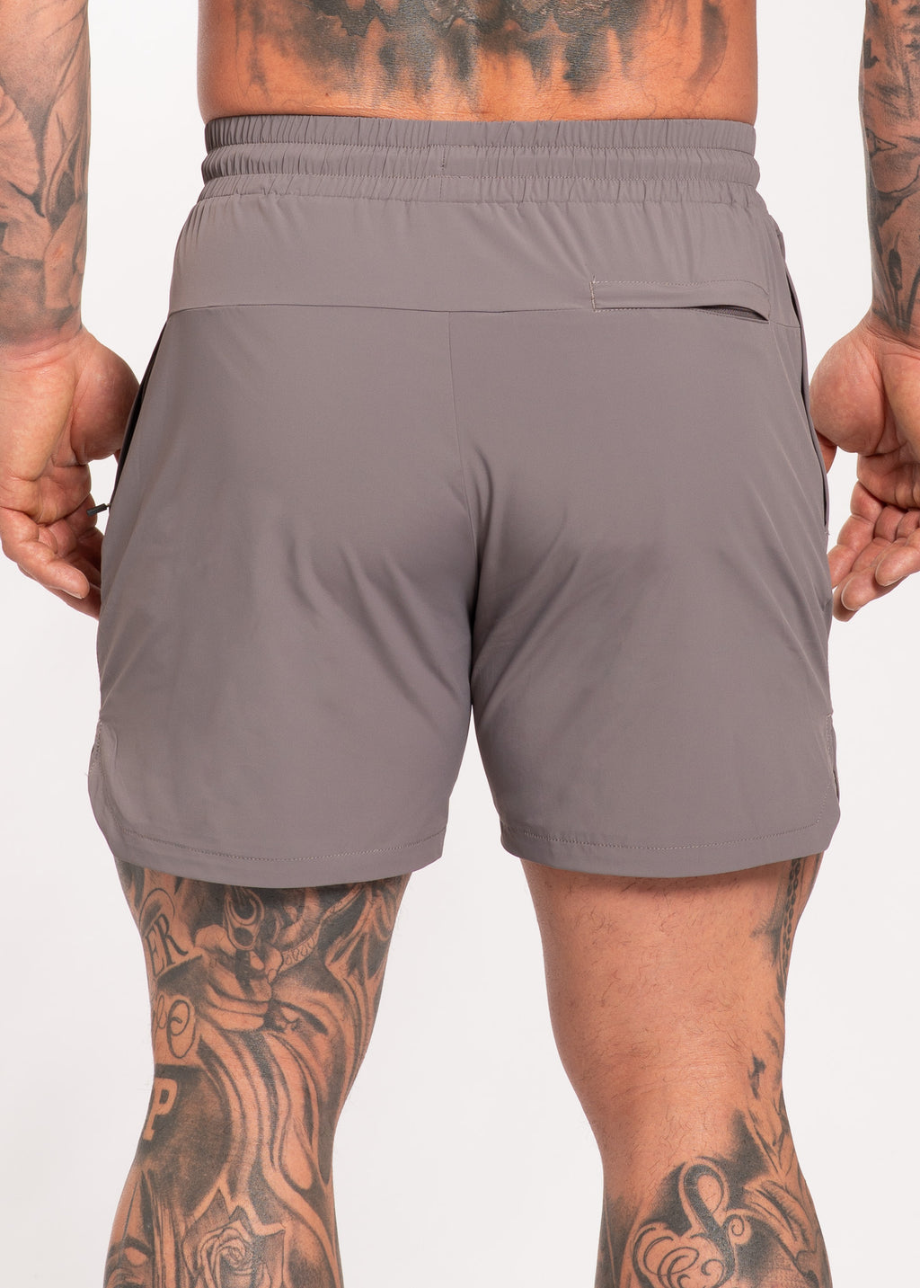 Gray performance gym shorts with back pocket, worn by tattooed athlete for training and fitness