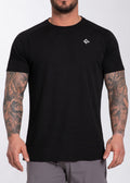 Black performance gym t-shirt with textured fabric and small white logo, worn by tattooed man for training