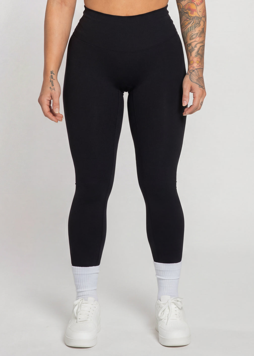 Black high-waisted gym leggings with white sneakers, perfect for training and active lifestyle