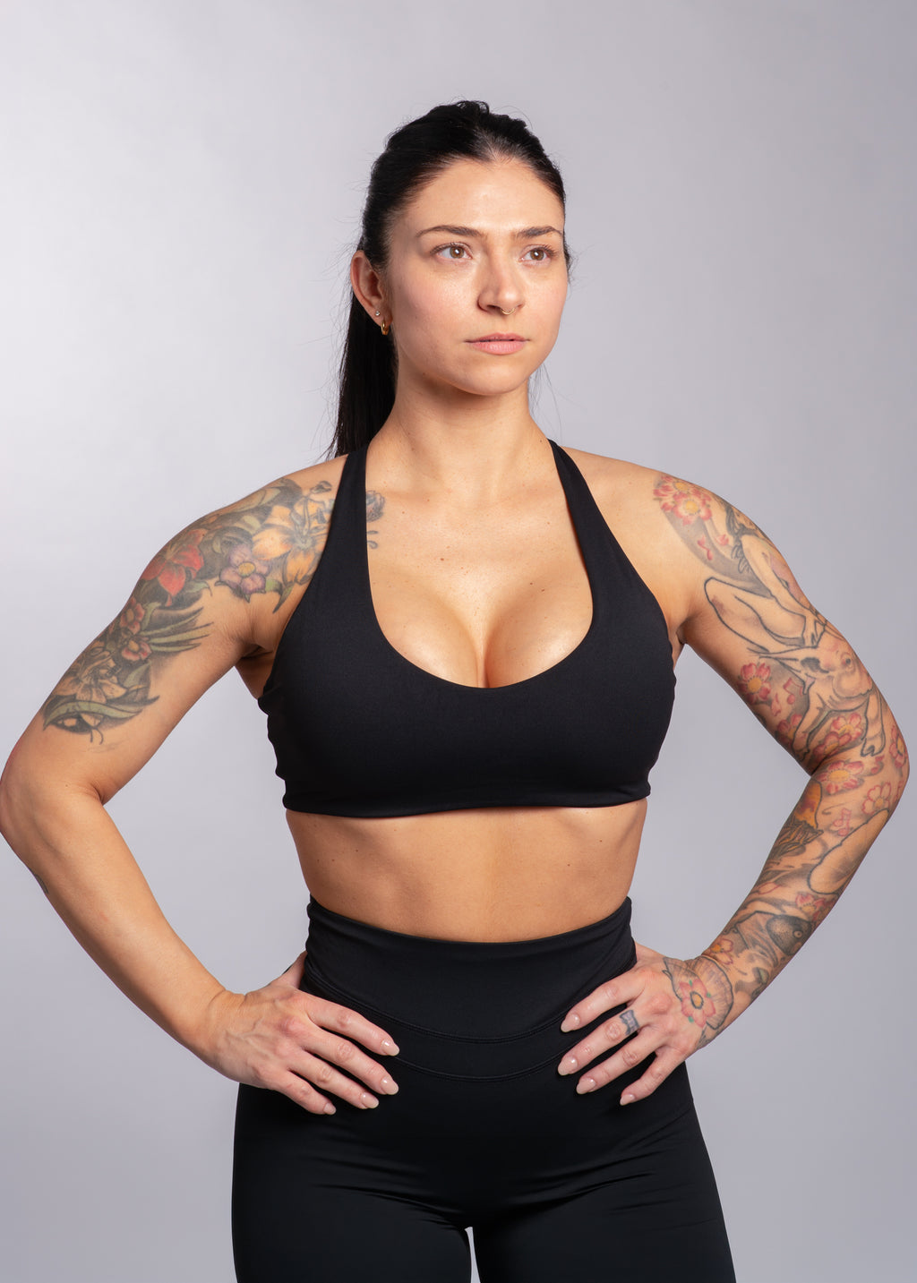 Woman in black sports bra and leggings, showcasing athletic wear for gym training and fitness