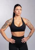 Woman in black sports bra and leggings, showcasing athletic wear for gym training and fitness