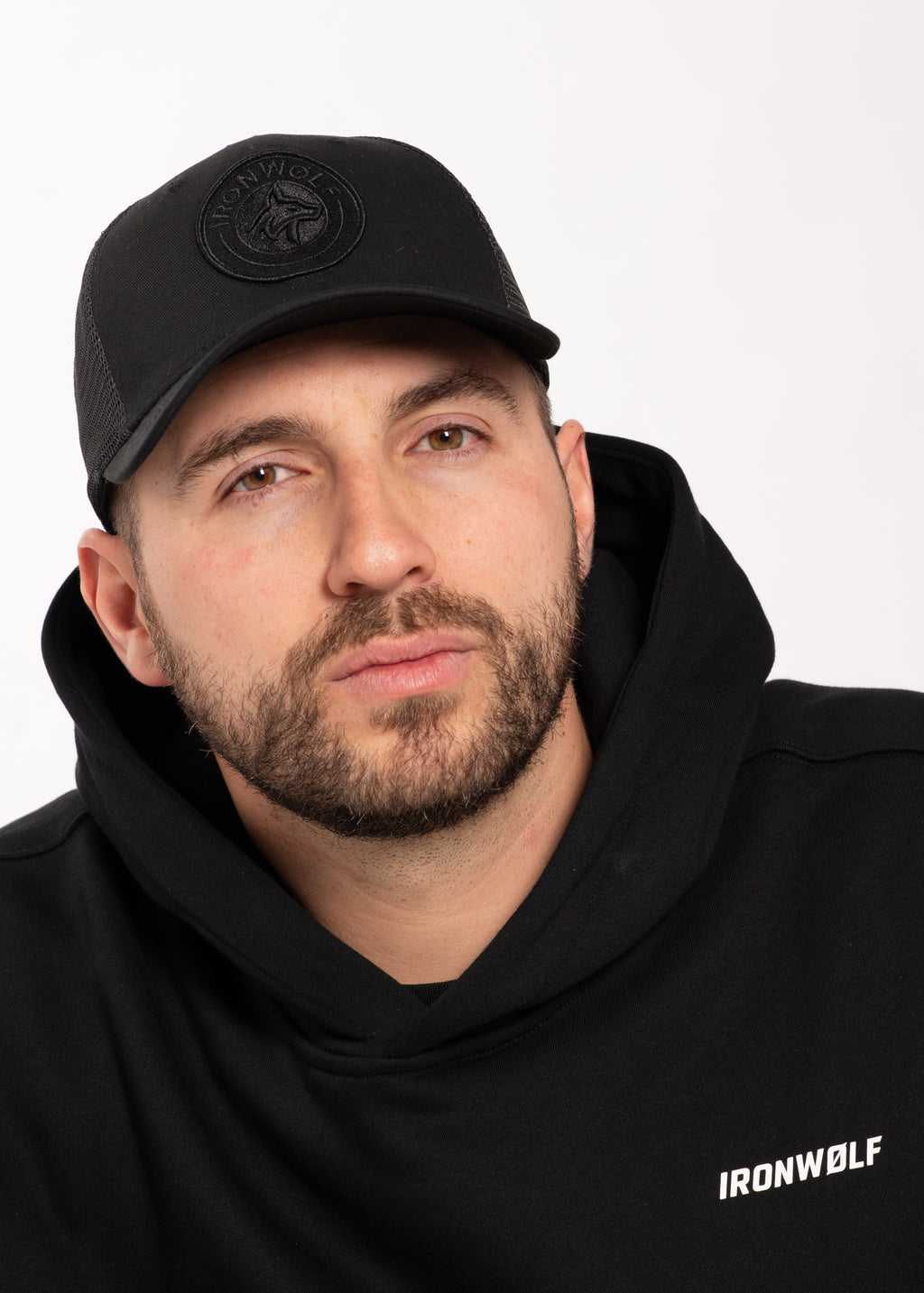 Man wearing black IRONWØLF hoodie and cap, fitness apparel for gym and lifestyle