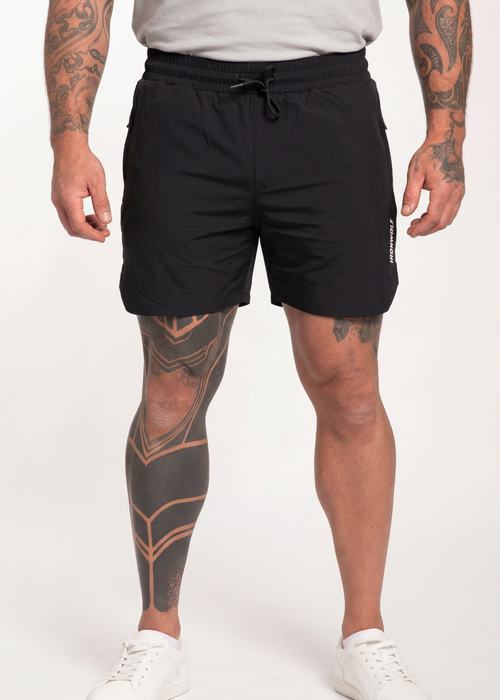 Men's black drawstring gym shorts with side logo, worn with white sneakers for workout or casual wear