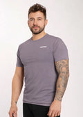 Man wearing gray IRONWØLF gym t-shirt with chest logo, showcasing athletic fit and tattooed arm