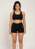 Woman in black high-performance gym wear: sports bra and shorts for training and active lifestyle