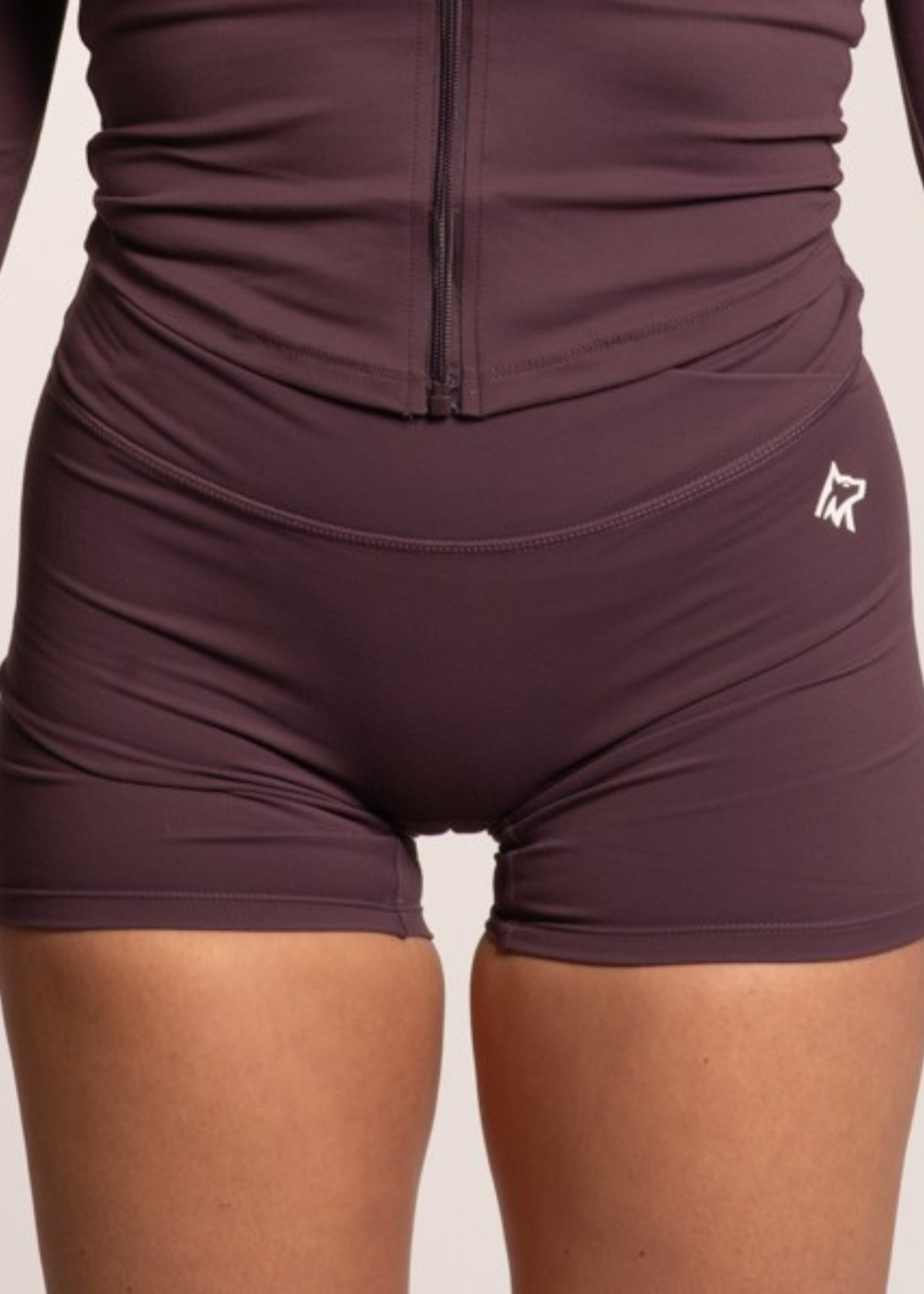 Purple high-waisted gym shorts with front zipper, designed for comfort and performance during workouts.