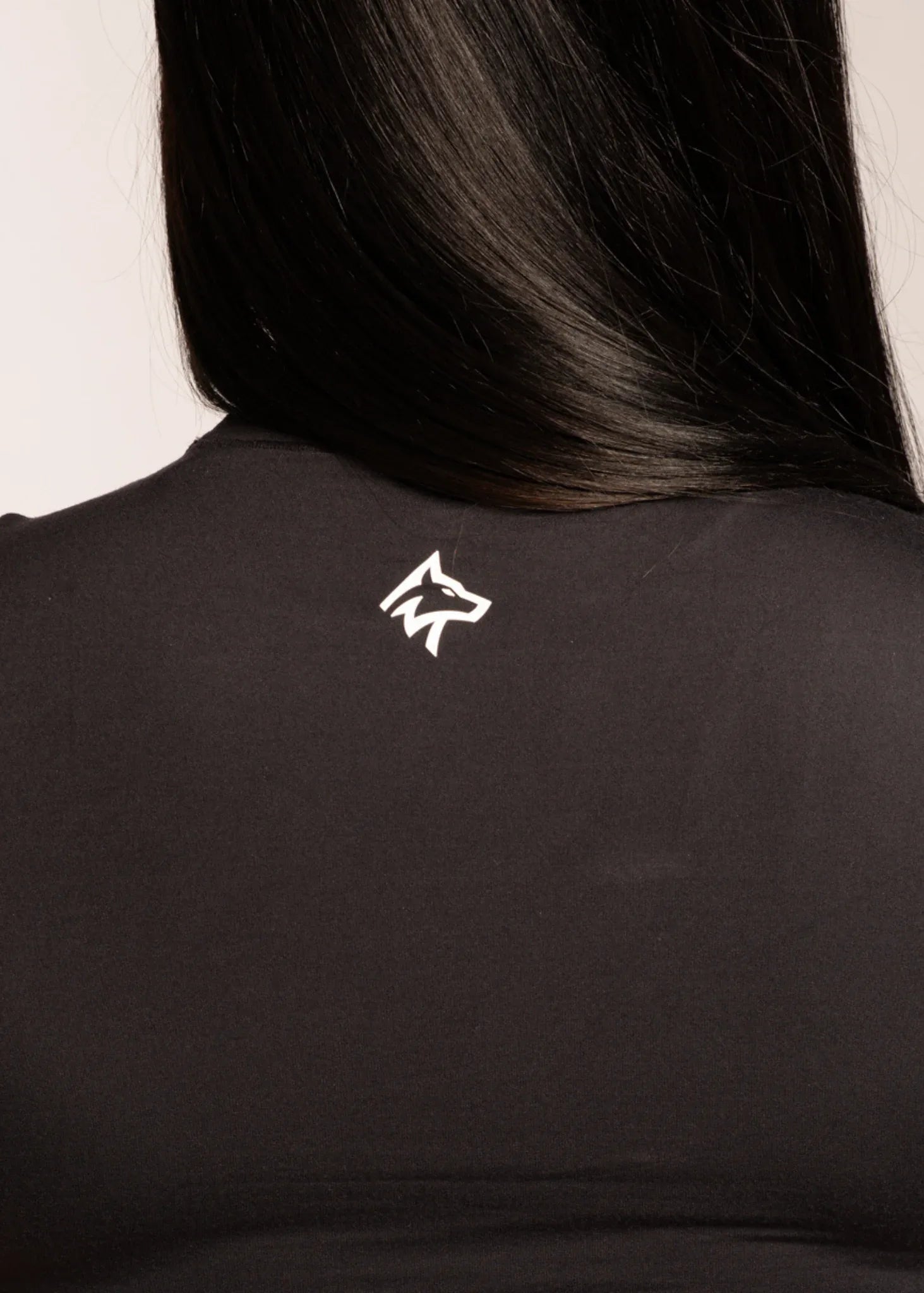 Black activewear top with white wolf logo on back, designed for gym and lifestyle wear