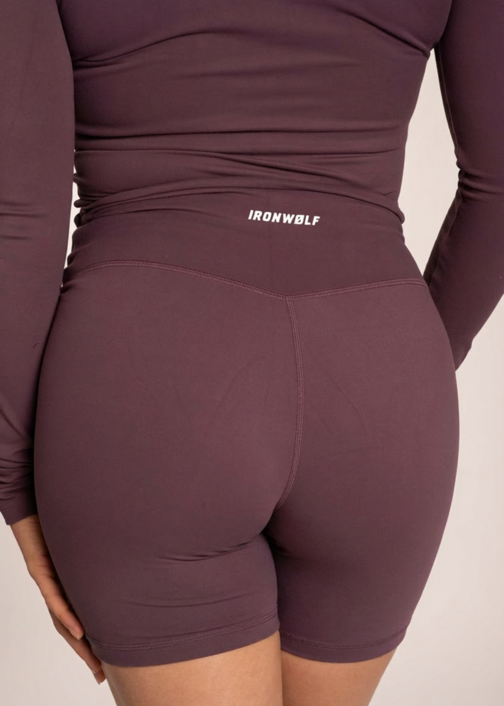 Purple IRONWØLF gym wear set with high-waisted biker shorts and long sleeve top for training comfort