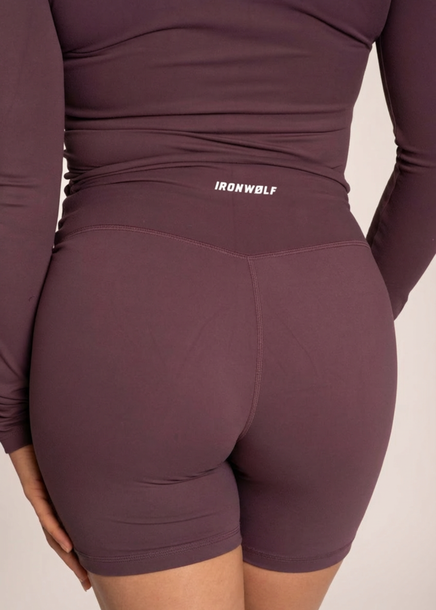 Purple IRONWØLF gym wear set with high-waisted biker shorts and long sleeve top for training comfort
