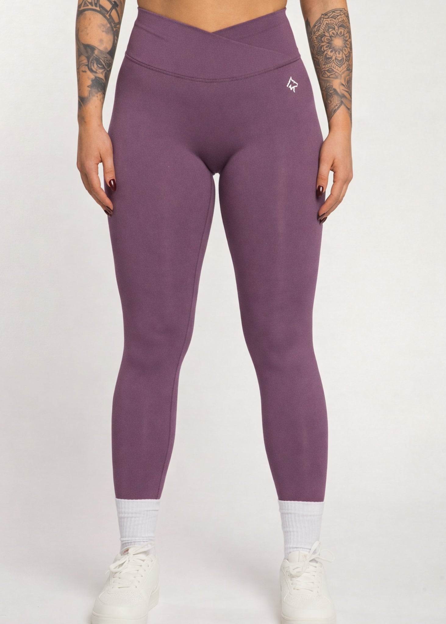 Purple high-waisted gym leggings with crossover waistband, ideal for training and active lifestyle