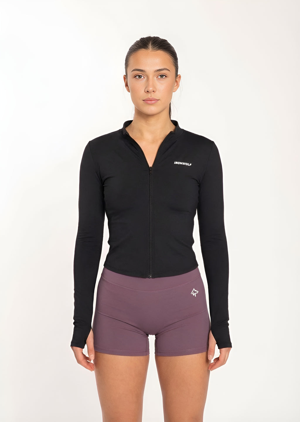 Woman in black zip-up gym jacket and purple workout shorts, fitness activewear for training and movement