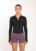 Woman in black zip-up gym jacket and purple workout shorts, fitness activewear for training and movement