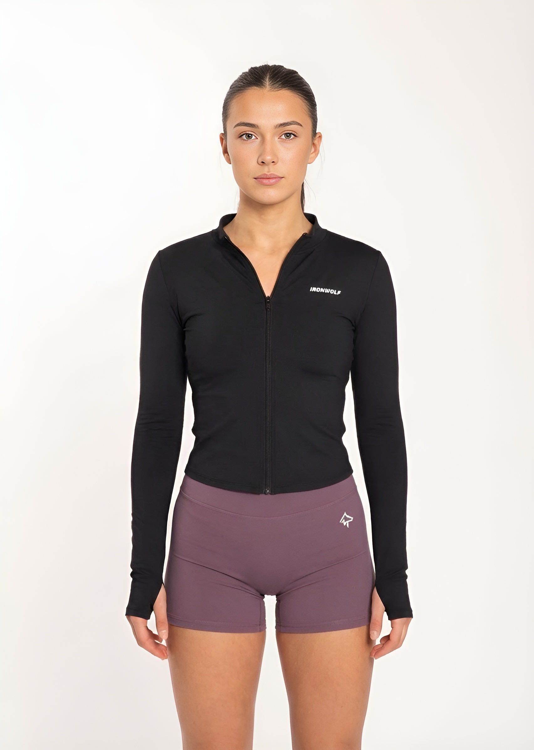 Woman in black zip-up gym jacket and purple workout shorts, fitness activewear for training and movement