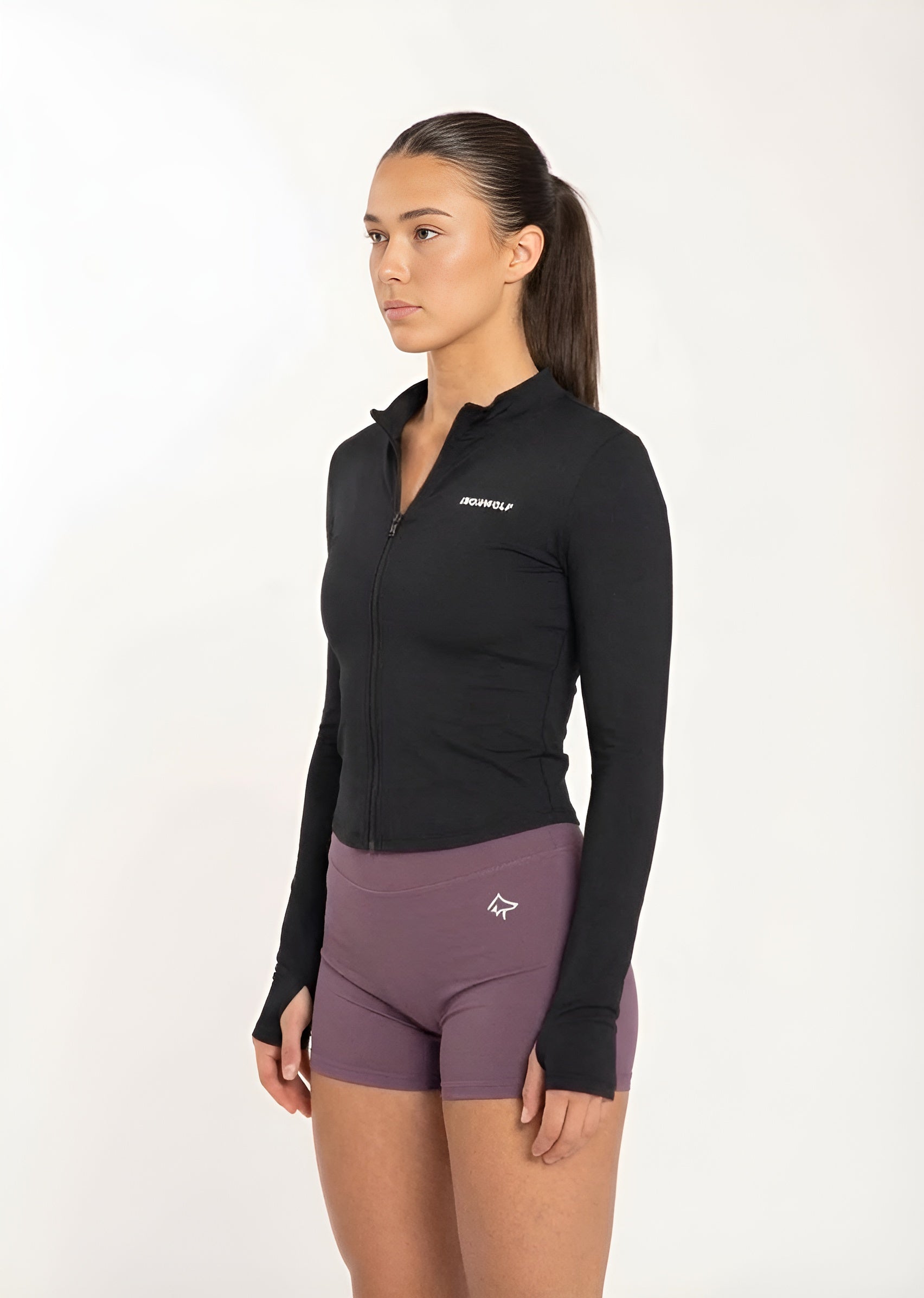 Woman in black zip-up gym jacket and purple workout shorts, fitness activewear for training and movement