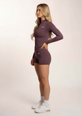Woman in purple gym wear set with long sleeve zip-up top and shorts, styled for training and comfort